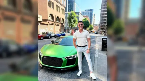 James Blake James Blake beside a sportscar