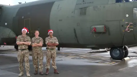 MOD Three members of the royal air force stand in front of a plane