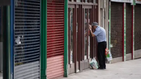 Getty Images A man looking through a shop window