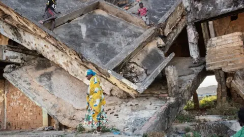 AFP Children play in a derelict building damaged during the civil war in Angola, Kuito - 2019