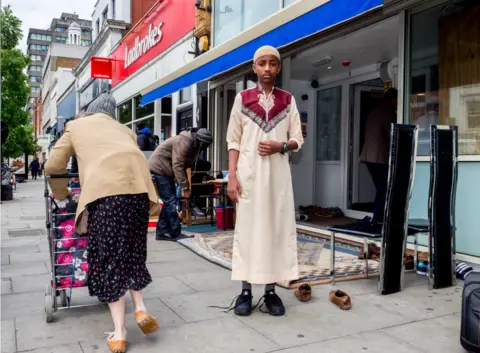 Peter Dench A young worshipper arrives for Friday prayer at the Holloway Mosque in London.
