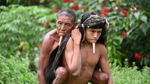 Erik Jennings Simões Tawy Zo'e carrying his father