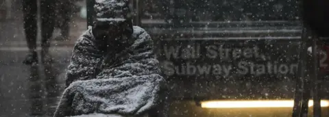 Getty Images A homeless man sits in the falling snow in the Financial District, January 30, 2019 in New York City.