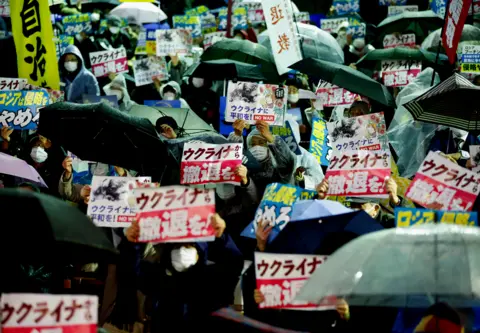 ISSEI KATO/ REUTERS Protesters show off placards, as they hold a rally against Russia's aggression on Ukraine, on the day to mark the first anniversary of the Ukraine War, in Tokyo, Japan February 24, 2023.