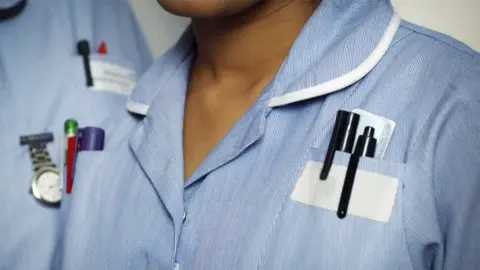 Universal Images Group/Getty Close-up of two typically dressed NHS nurses