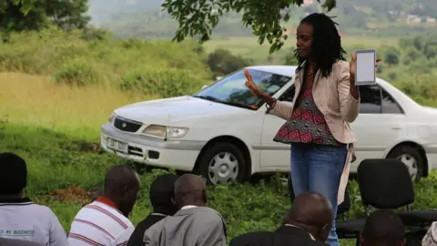 Catherine Nakalembe Catherine Nakalembe talking to a group of men