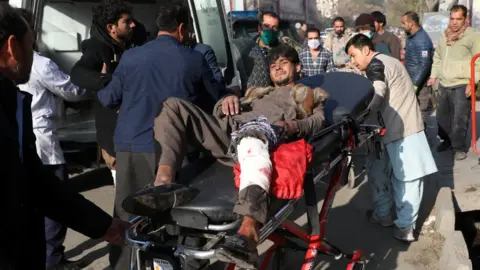 Reuters An injured man is carried to a hospital after rockets hit residential areas in Kabul