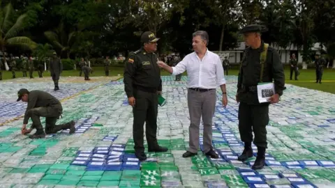 EPA A handout photo made available by the Presidency of Colombia shows the Colombian President Juan Manuel Santos (2R) in the middle of packages containing cocaine, in Apartado, in the Department of Antioquia, Colombia, 08 November 2017