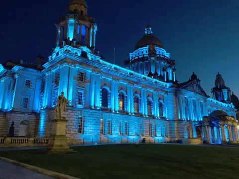 PA Media Belfast City Hall lit up in blue