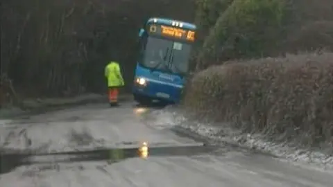 A bus leaning over after skidding into a ditch