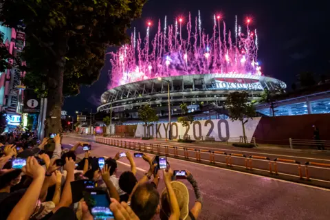Yuichi Yamazaki / Getty Images People take photographs of fireworks during the opening ceremony of the Tokyo 2020 Olympic Games at Olympic Stadium, on 23 July 2021, in Tokyo, Japan