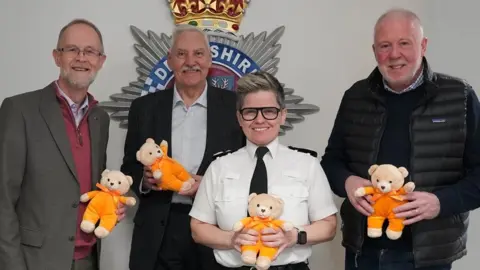 Derbyshire Police Police and charity officials holding teddy bears
