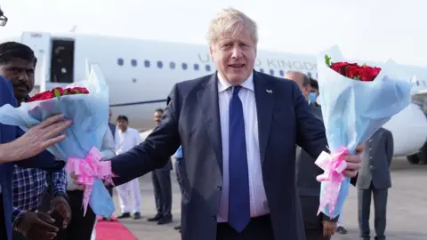 PA Media Boris Johnson arriving in Gujarat airport, being welcomed with roses