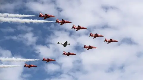 Getty Images The Reds Arrows perform a flypast with a Spitfire at the start of the 2018 show