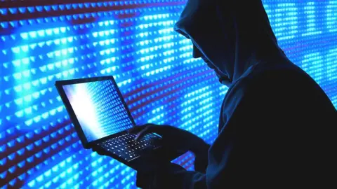 Getty Images A man wearing a hood hood using a laptop