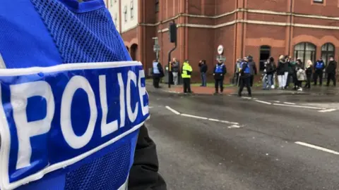 Emma Baugh / BBC Demonstrators in Ipswich, with a police officer in the foreground