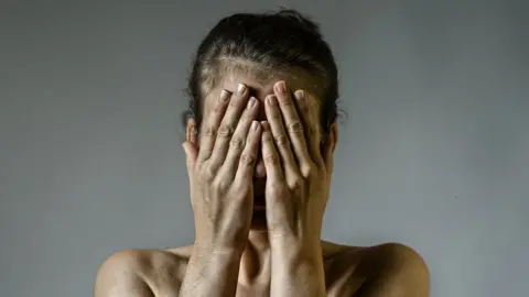 Getty Images A woman with hands over her face