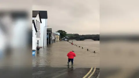 Dafydd Williams man walking through flooded street