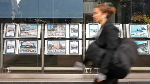 AFP A woman walks past an estate agents window in September 2022