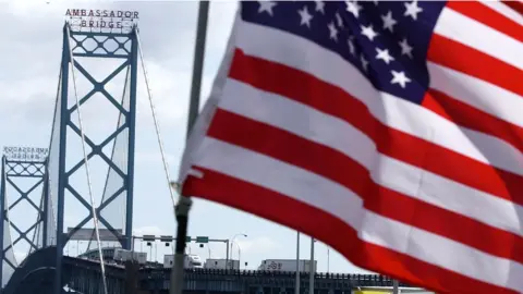 Getty Images Trucks head to US customs after crossing the Ambassador Bridge that connects Detroit, Michigan, and Windsor, Ontario, Canada, 28 September 2001.