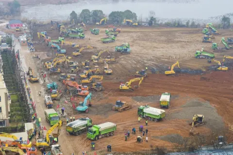 Getty Images An aerial view of cranes and diggers building Huoshenshan Hospital
