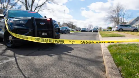 Police officers from the Falls Township Police Department tape off and inspect the scene of one of three shootings in the Vermillion Hills neighbourhood on March 16, 2024 in Levittown, Pennsylvania