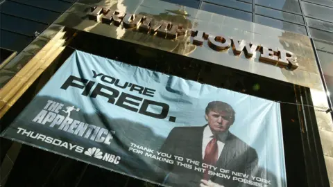 Getty Images A advert for The Apprentice hung at Trump Tower