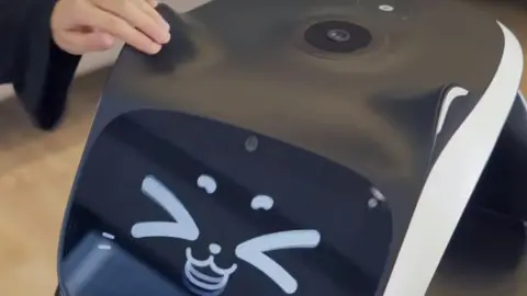 PuduTech A customer stroking the robot's ear