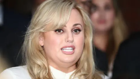 Getty Images Rebel Wilson speaking to the press after winning her defamation case in June 2017