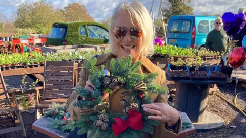 Kim Wilde holding a wreath on site