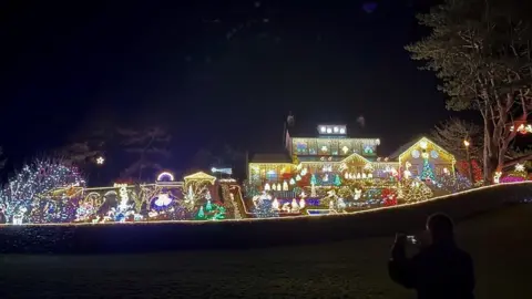 Jeremy Voakes A man takes a picture of the illuminations at Cark