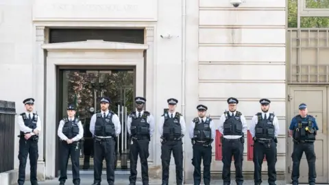 PA Media Police officers watch a memorial service for PC Yvonne Fletcher on the 38th anniversary of her death