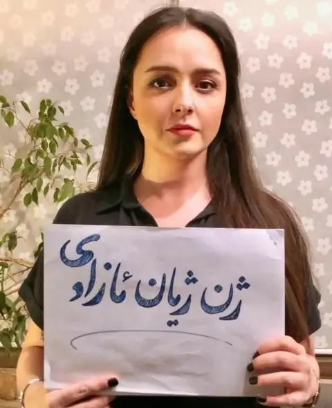 Taraneh Alidoosti Taraneh Alidoosti poses for a photograph without a headscarf and holding a sign bearing the protest slogan: "Woman, life, freedom"