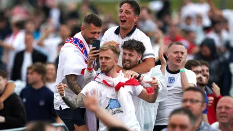 PA Media Fans in Manchester cheer Harry Maguire's goal for England