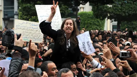 Getty Images Maya Jeribi, general secretary of the opposition Progressive Democratic party takes part in a protest, Tunis, 14 January 2011