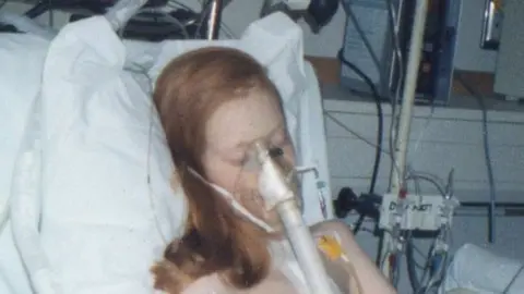 Michelle Crawford Michelle in hospital bed hooked up to machines.