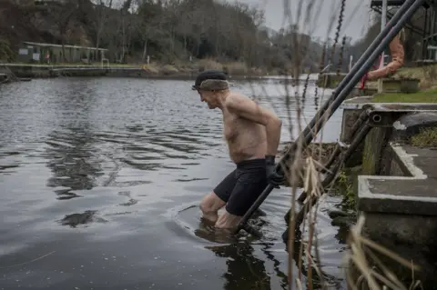 James Beck A man climbs into water