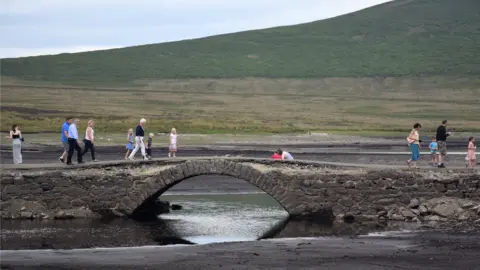 Ivor Anderson People walking across the bridge at Spelga Reservoir