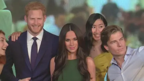 Reuters Visitors take selfies with wax figures of Harry and Meghan in Madame Tussauds London