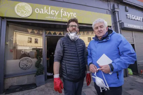 PA Media Darren Kearney and Brendan Teggart outside their cafe Oakley Fayre in Downpatrick after it was flooded last week