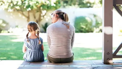 Getty Images A woman and child sit together on a porch