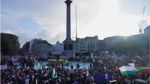 Getty Images A large crowd gathers in Trafalgar Square holding Palestinian flags and placards