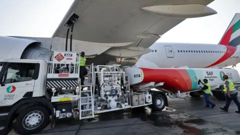 Getty Images Ground crews prepare an Emirates Boeing 777-300ER aircraft, powering one of its engines with a hundred per cent Sustainable Aviation Fuel (SAF), in Dubai, on January 30, 2023