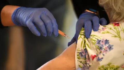 OLI SCARFF/Getty Images Vaccination being given
