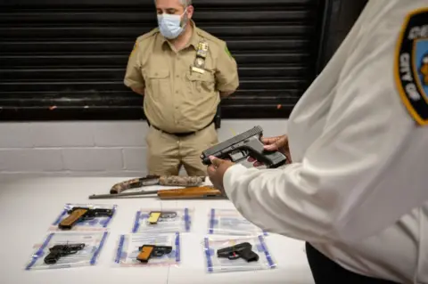 Getty Images Officers display guns recovered from New York City streets