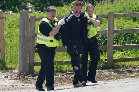 PA Media Two officers escort Daniel Boulton to a police van