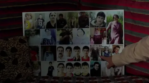 A man points at collage photograph of relatives