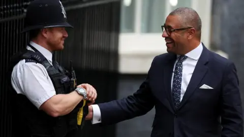 Reuters James Cleverly talking to a policeman outside 10 Downing Street