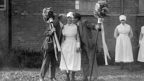 Getty Images A nurse receives kiss as part of the Hocktide event in April 1926