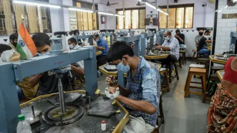 Getty Images Workers examine diamond stones